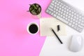 Office table with keyboard, mouse, notebook and smartphone on modern two tone white and pink background Royalty Free Stock Photo