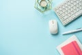 Office table with keyboard, notebook and pen on blue background. Royalty Free Stock Photo