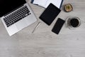 Office table with laptop computer, notebook, digital tablet, pen, smartphone, mouse and coffee on white wood background Royalty Free Stock Photo