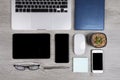 Office table with laptop computer, notebook, digital tablet, pen, smartphone, mouse, eyeglasses and coffee on wood background Royalty Free Stock Photo