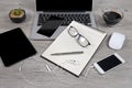 Office table with laptop computer, notebook, digital tablet, pen, smartphone, mouse, eyeglasses and coffee on wood background Royalty Free Stock Photo