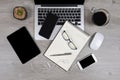 Office table with laptop computer, notebook, digital tablet, pen, smartphone, mouse, eyeglasses and coffee on wood background Royalty Free Stock Photo