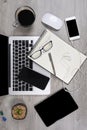 Office table with laptop computer, notebook, digital tablet, pen, smartphone, mouse, eyeglasses and coffee on wood background Royalty Free Stock Photo