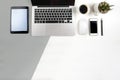 Office table with laptop computer, notebook, digital tablet and smartphone on modern two tone white and grey background Royalty Free Stock Photo