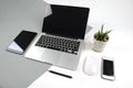 Office table with laptop computer, notebook, digital tablet and smartphone on modern two tone white and grey background Royalty Free Stock Photo