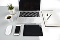 Office table with laptop computer, notebook, digital tablet and smartphone on modern two tone white and grey background Royalty Free Stock Photo