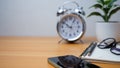 Office table of modern workplace with notebooks and pencils, phone, clock on wooden table. side view and copy space on wooden Royalty Free Stock Photo