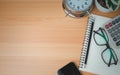 Office table of modern workplace with notebooks and pencils, phone, clock on wooden table. side view and copy space on wooden Royalty Free Stock Photo