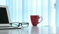 Office table with notebook laptop, eading glasses and coffee mug. Copy space Royalty Free Stock Photo