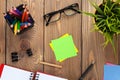 Office table with notepad, colorful pencils, supplies and flower