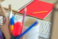 Office table soft focus indoor picture of red notebook paper pencil computer keyboard Royalty Free Stock Photo