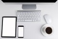 Office table with tablet computer and smartphone, wireless computer keyboard and mouse, cup of coffee, copy space notebook. empty Royalty Free Stock Photo