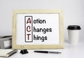 Office table with wooden frame with text - Action Changes Things