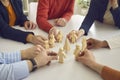 Office team of people sitting at a table and arranged in a circle wooden figures of people. Royalty Free Stock Photo