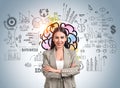 Businesswoman with arms crossed, colourful brain sketch on blue Royalty Free Stock Photo