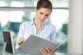 office woman in white shirt holding document folder