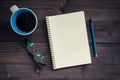 Office wood table with blank notepad, pencil, glasses and cup of Royalty Free Stock Photo