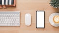 Office wooden desk workplace with blank screen smart phone, keyboard, mouse, notebook and cup of coffee Royalty Free Stock Photo