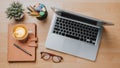 Office wooden desk workplace with laptop computer, notebook, pen, eyeglass and cup of coffee, Top view Royalty Free Stock Photo