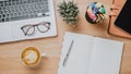 Office wooden desk workplace with laptop computer, tablet, notebook, pen and cup of coffee Royalty Free Stock Photo