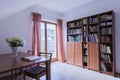 Office with wooden table and bookstand