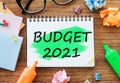 Office wooden table Budget 2021 the text is written in a notebook with markers, paper clips, crumpled paper. Business concept top Royalty Free Stock Photo