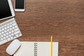 Office wooden table with notebook, yellow pencil, tablet, keyboard, mouse and smartphone Royalty Free Stock Photo