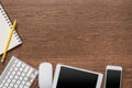 Office wooden table with notebook, yellow pencil, tablet, keyboard, mouse and smartphone Royalty Free Stock Photo