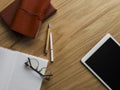 Office work accessories - tablet, notebook, notepad, stationery, glasses on a wooden desktop, top view