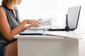 Office work, freelance and business. Young blonde woman reading a book and working with a computer. Close up Royalty Free Stock Photo