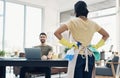 Office work vs household work. a young woman cleaning the house while her husband uses a laptop. Royalty Free Stock Photo