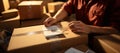 Office worker affixes label on package in close-up courier delivery scene. Royalty Free Stock Photo