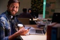 Office Worker With Coffee At Desk Working Late On Laptop Royalty Free Stock Photo