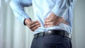 Office worker feeling sharp back pain, sedentary lifestyle, slipped disc