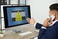 Office worker in front of computer with warning about virus attack on screen Royalty Free Stock Photo