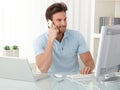 Office worker guy using computer and phone Royalty Free Stock Photo