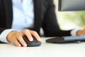 Office worker hand using computer mouse on a desk