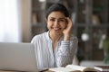 Smiling young mixed race woman employee posing by work desk Royalty Free Stock Photo