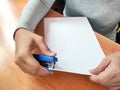 An office worker is stapling papers at her desk Royalty Free Stock Photo