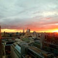 Office worker taking pictures on mobile of the stunning sunrise over looking St Paul`s cathedral