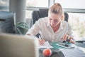 Office worker at workplace. Girl writing on paper.