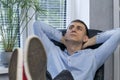 Office worker at workplace rests in chair with his feet on the table. Anticipation of vacation. Lazy employee Royalty Free Stock Photo