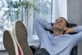 Office worker at workplace rests in chair with his feet on the table. Anticipation of vacation. Lazy employee. Focus on feet Royalty Free Stock Photo