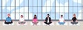 Office workers dressed in smart clothes sit with crossed legs and meditate against panoramic window on background