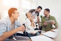 Office workers and a person in a wheelchair discuss working matters. They work in a bright office. Royalty Free Stock Photo