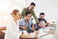 Office workers and a person in a wheelchair discuss working matters. They work in a bright office. Royalty Free Stock Photo