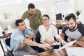 Office workers and a person in a wheelchair discuss working matters. They work in a bright office. Royalty Free Stock Photo