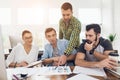 Office workers and a person in a wheelchair discuss working matters. They work in a bright office. Royalty Free Stock Photo