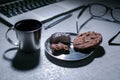 Office working desk with laptop, pen and and glasses and coffee with cookie and sweets Royalty Free Stock Photo