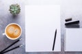 Office workplace with blank paper, cup of coffee, note pad and pen. Stone background. Top view Royalty Free Stock Photo